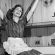 1950s housewife smiling sitting on countertop